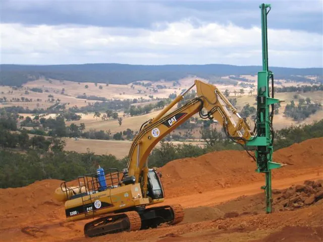 Montabert CPA on a Cat 330D excavator drilling on an elevated bench