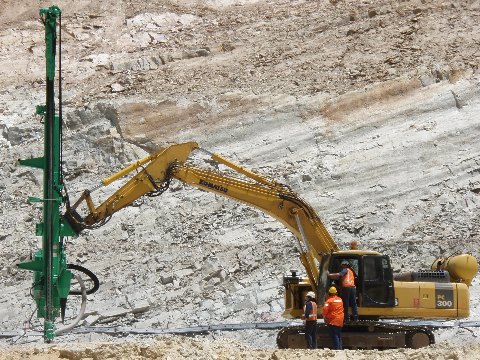 Montabert CPA drilling a vertical rock face on a Komatsu PC300 at a quarry